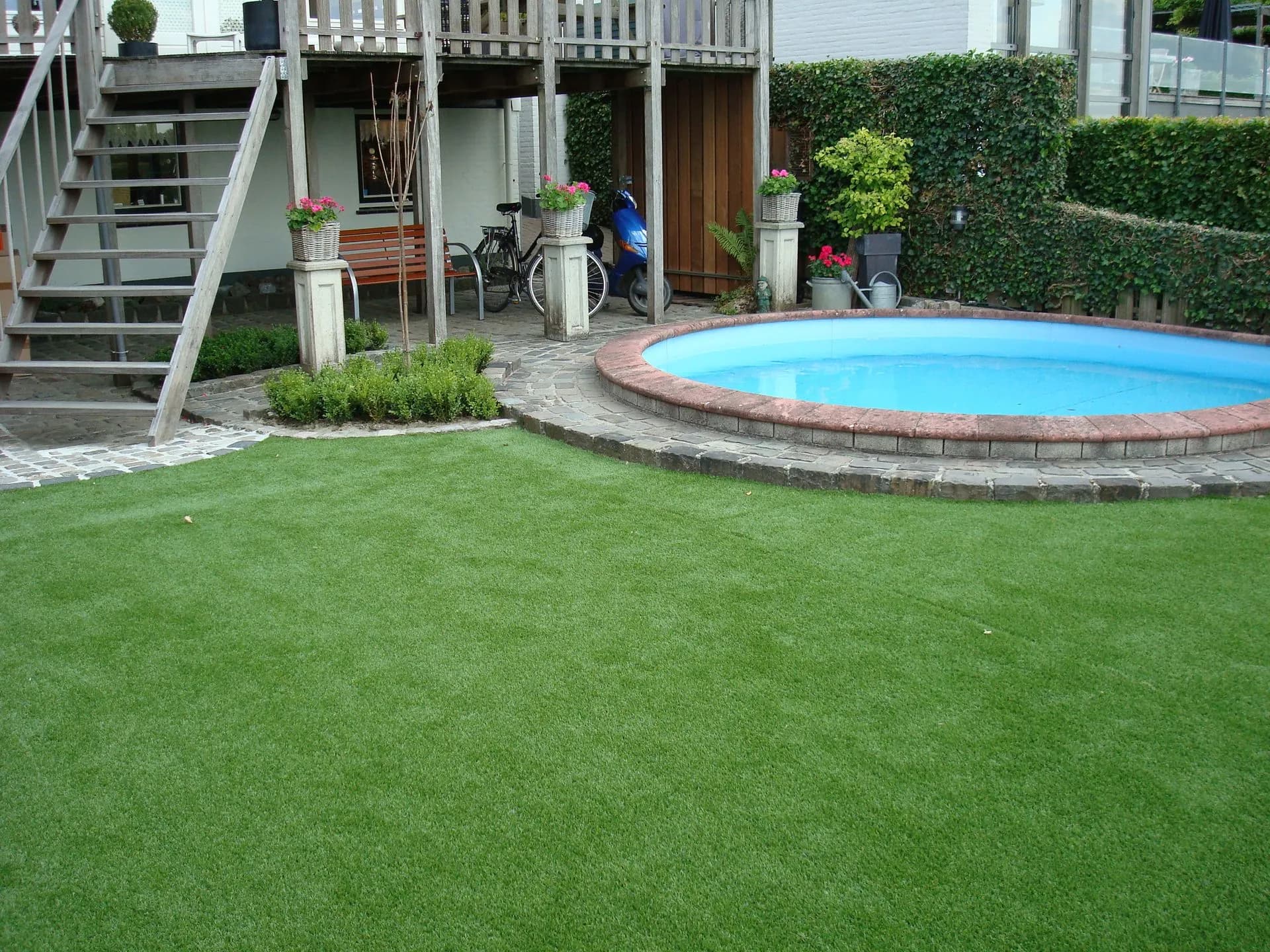 Verzorgde tuin met gazon en zwembad aangelegd door Out-living